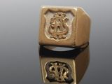 an image of a gold ring with a crest and a crown on it