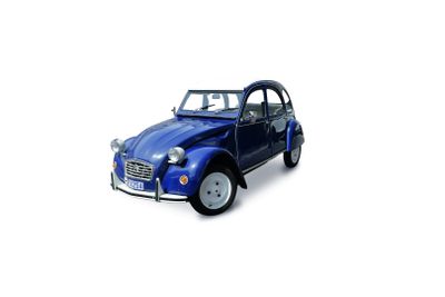 une petite voiture bleue garée sur une surface blanche