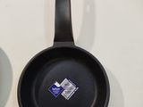 two frying pans hanging on the wall next to each other