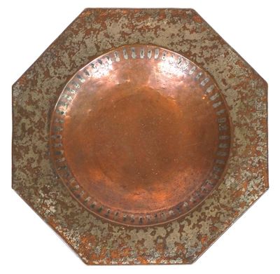 a copper plate with a design on it on a white background
