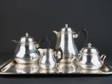 a silver tray with a silver tea set on it