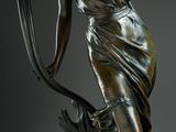 a bronze statue of a woman holding a bow and arrow