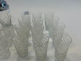 bottles and glasses are lined up on a table with a shaker