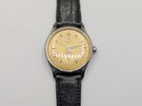 an image of a wrist watch with a gold face and black leather strap