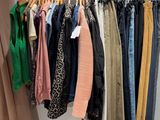 a rack of clothes hanging on a rail in a room
