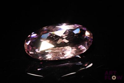 a close up of a pink diamond on a black surface