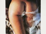 an image of a nude woman sitting on a fur covered couch