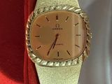 an image of a gold watch on a red cloth