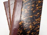 trois carnets en cuir marron et noir empilés les uns sur les autres
