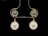 a close up of a pair of earrings with pearls on them