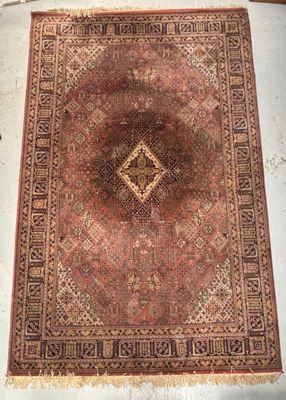 un vieux tapis orné d'un motif en losanges, posé sur le sol