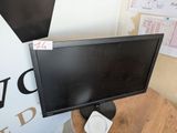 a computer monitor sitting on top of a wooden table