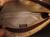 a person holding a purse that is open on a table