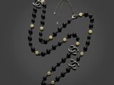 un ensemble composé d'un collier et de boucles d'oreilles en perles noires et blanches