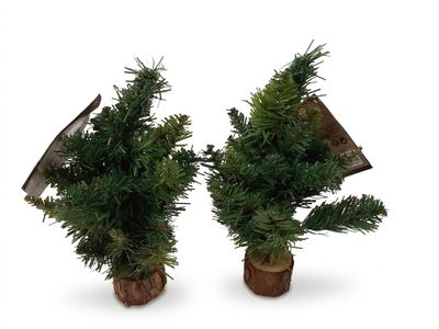 deux petits sapins de Noël posés sur des souches en bois, sur fond blanc