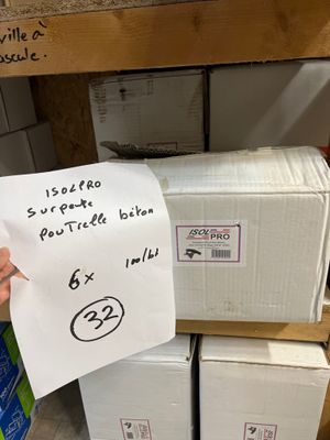 quelqu'un tient devant une pile de cartons une feuille de papier sur laquelle figure un dessin