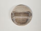 an image of a silver medal with a plaque on it