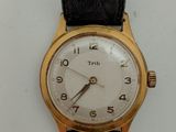 une montre-bracelet en or avec un cadran blanc et un bracelet en cuir noir