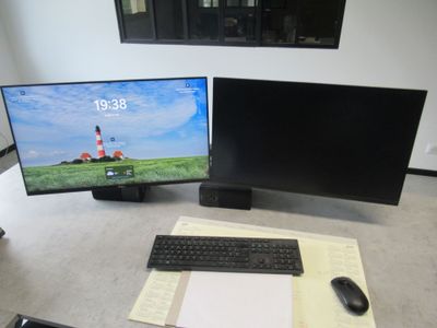 a computer desk with two monitors and a keyboard
