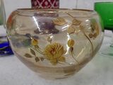 a glass bowl with flowers painted on it sitting on a table