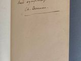 un livre ouvert, sur lequel on peut lire une inscription manuscrite, posé sur une table
