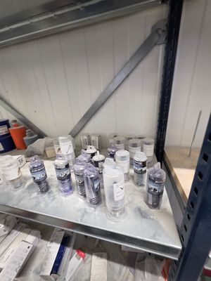 de nombreuses bouteilles d'eau posées sur une étagère dans une pièce