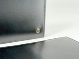 two black leather wallets sitting next to each other on a white surface