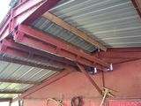 a red building with a metal roof and a metal roof