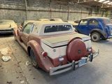 several old cars are parked in a garage next to each other