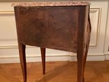 a small wooden table with a marble top on a hard wood floor