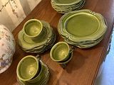 une table sur laquelle sont posés plusieurs assiettes et bols verts