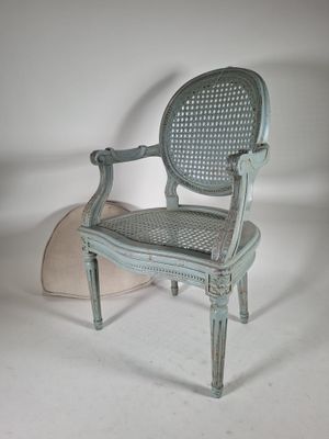 une chaise avec un coussin posé par terre à côté