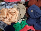 a suitcase full of clothes and a hat on the floor