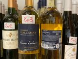 several bottles of wine are lined up on a counter