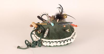 un sac à main vert orné de plumes et de perles