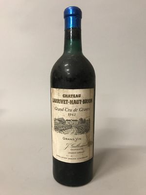 une bouteille de vin rouge posée sur une table blanche