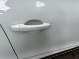 the door handle of a white car with a sticker on it