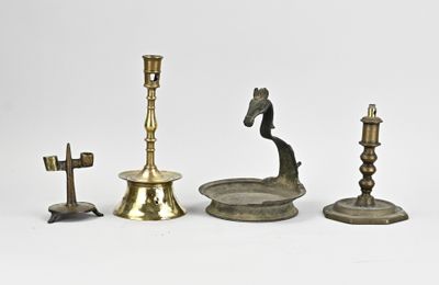 plusieurs types de bougies et de bougeoirs posés sur une surface blanche