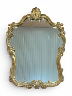 une image d'un miroir encadré d'or accroché à un mur