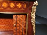 an ornately decorated sideboard with a drawer and a door