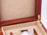 a wooden box with a watch inside of it