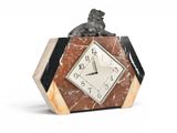 une horloge surmontée d'une statue représentant un chien assis