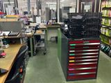 une photo d'une pièce avec de nombreux bureaux et de nombreuses étagères