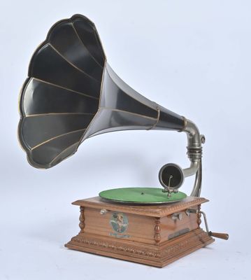 un vieux gramophone avec une plaque verte posée sur un socle en bois