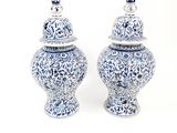 two blue and white vases sitting next to each other
