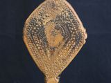 an antique wooden hand held mirror on a stand with a black background