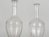 two clear glass vases sitting next to each other on a white surface