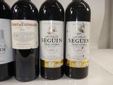 three bottles of red wine are lined up on a counter