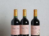 trois bouteilles de vin posées sur une table en bois
