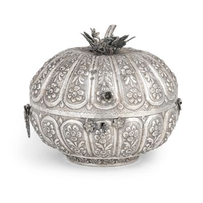 une boîte en argent finement décorée, surmontée d'un oiseau, sur fond blanc
